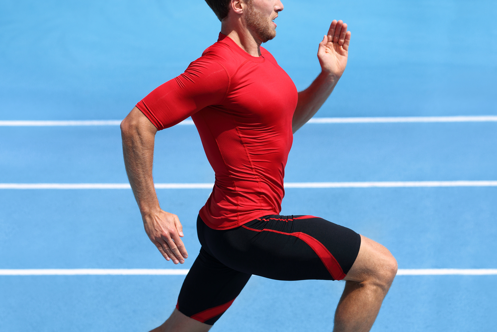 man in compression shorts running on track